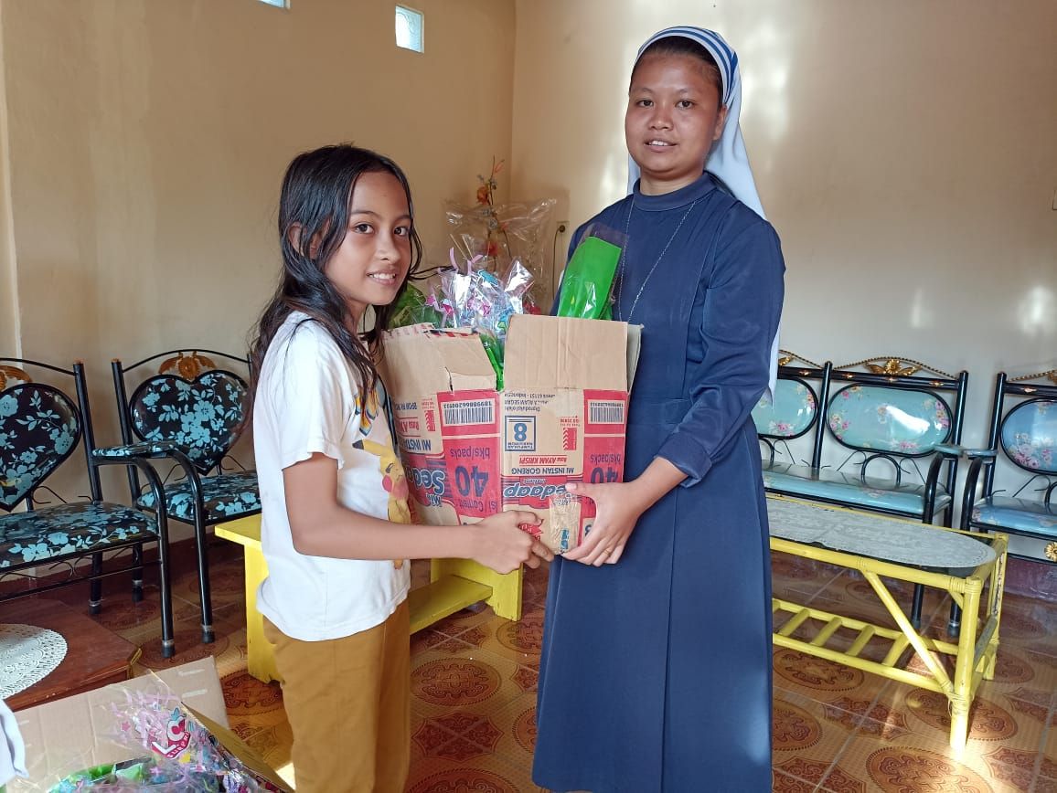Puteri menyerahkan bingkisannya diterima oleh Suster Stellamaris di Boawae. Inspiratif, satu keluarga di Nagekeo Flores rayakan sambut baru anaknya dengan cara berbeda.